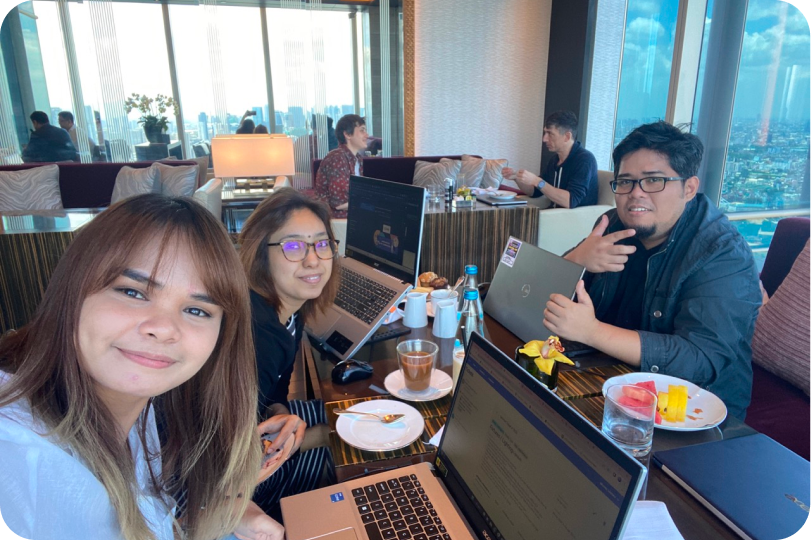 Nicole Llanes with her Cove Living team at a restaurant with laptops.